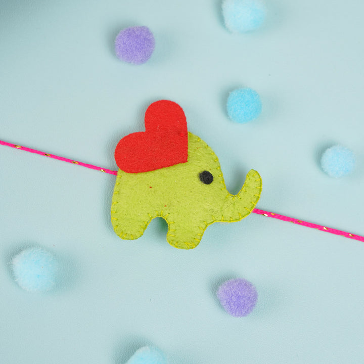 Customized Handmade Beaded Elephant Theme Pom Pom Felt Rakhi With Roli Chawal For Kids - Close-up of Green Elephant Charm Facing Right