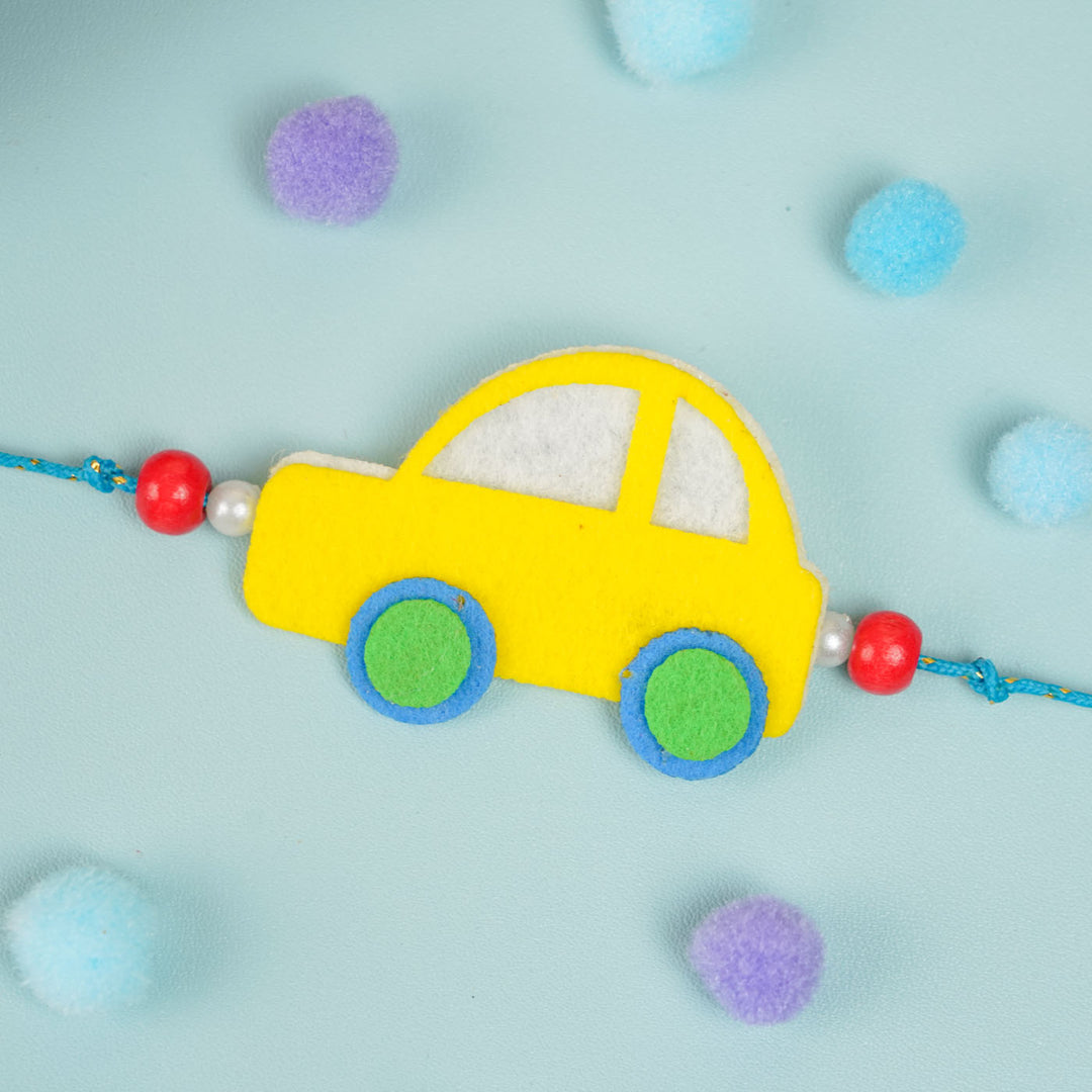 Customized Handmade Beaded Car Theme Pom Pom Felt Rakhi With Roli Chawal For Kids - Front view of yellow car charm