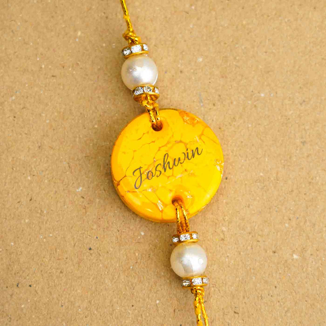 Personalized Handmade Yellow Resin Rakhi With Roli Chawal - Close-up of Name Personalization