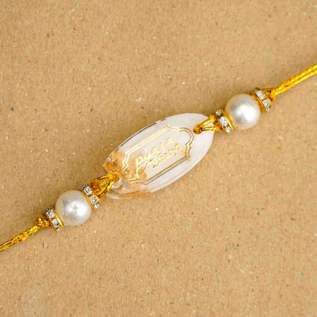 Personalized Handmade White Resin Rakhi With Roli Chawal - Close-up of Oval Design Rakhi