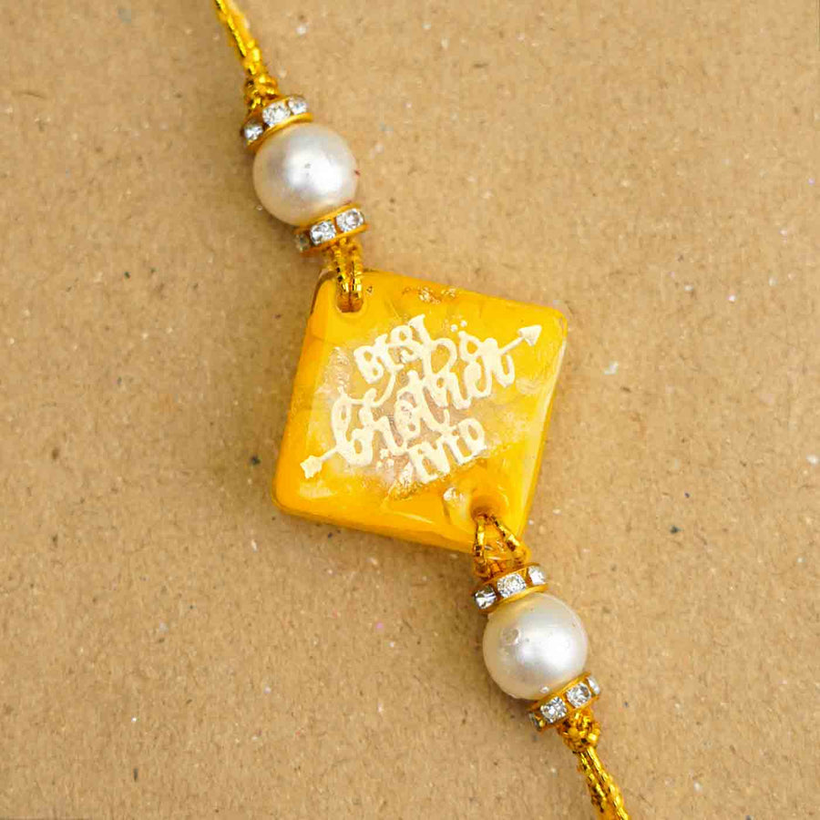 Personalized Handmade Yellow Resin Rakhi With Roli Chawal - Close-up of Bracelet Charm