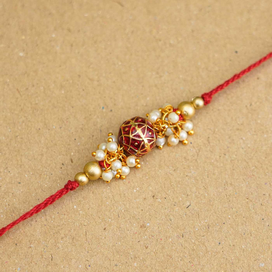 Handmade Red Meena Bead Pearl Rakhi With Roli Chawal - Close-up of Rakhi centerpiece