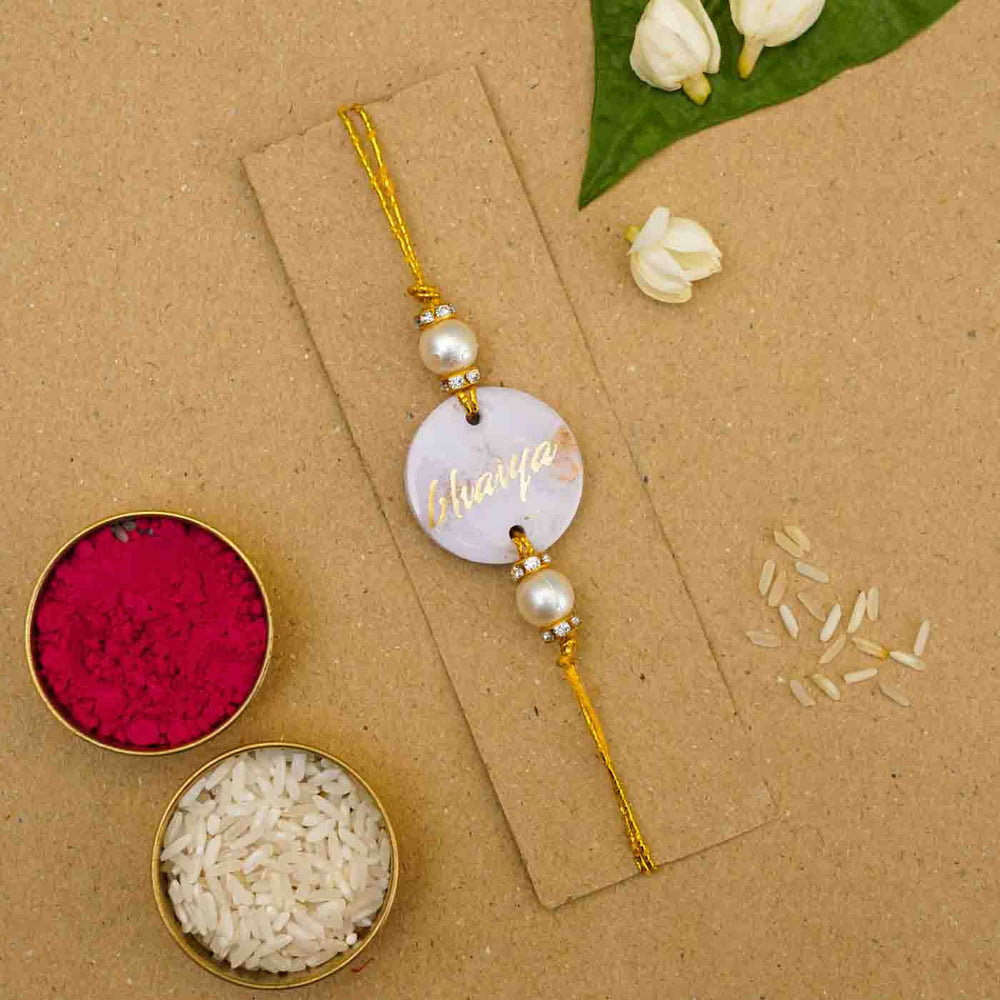 Personalized Handmade Lavendar Resin Rakhi With Roli Chawal - Flat Lay with Rice and Red Powder