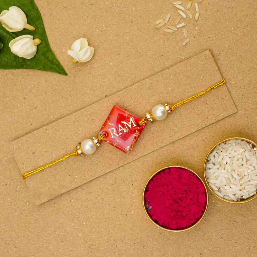 Personalized Handmade Red Resin Rakhi With Roli Chawal - Flat lay with rakhi and accessories