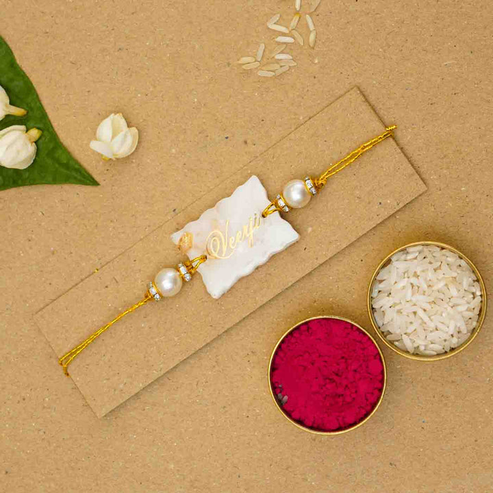 Personalized Handmade White Resin Rakhi With Roli Chawal - Flat Lay with Rice and Kumkum