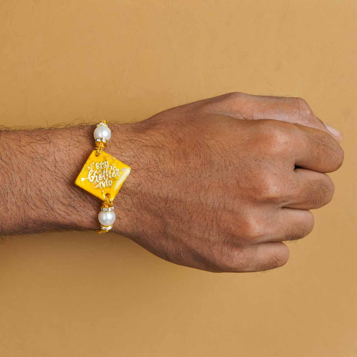 Personalized Handmade Yellow Resin Rakhi With Roli Chawal - On Hand Wear Display