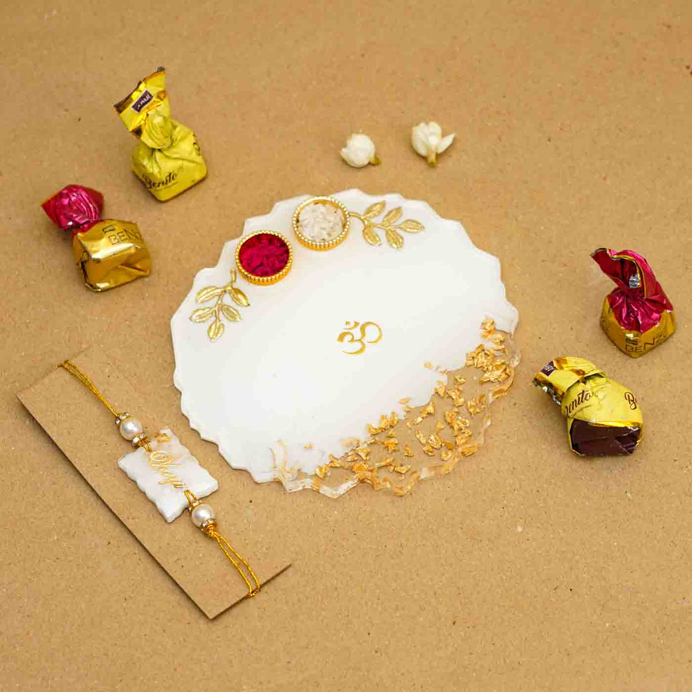 Personalized Handmade White Resin Rakhi Thali With Roli Chawal For Brother Set Of 2 - Flat Lay with Rakhi, Plate, and Chocolates