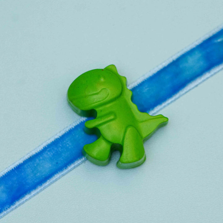 Handmade Dino Crayon Kids Rakhi With Roli Chawal - Close-up of green dinosaur charm