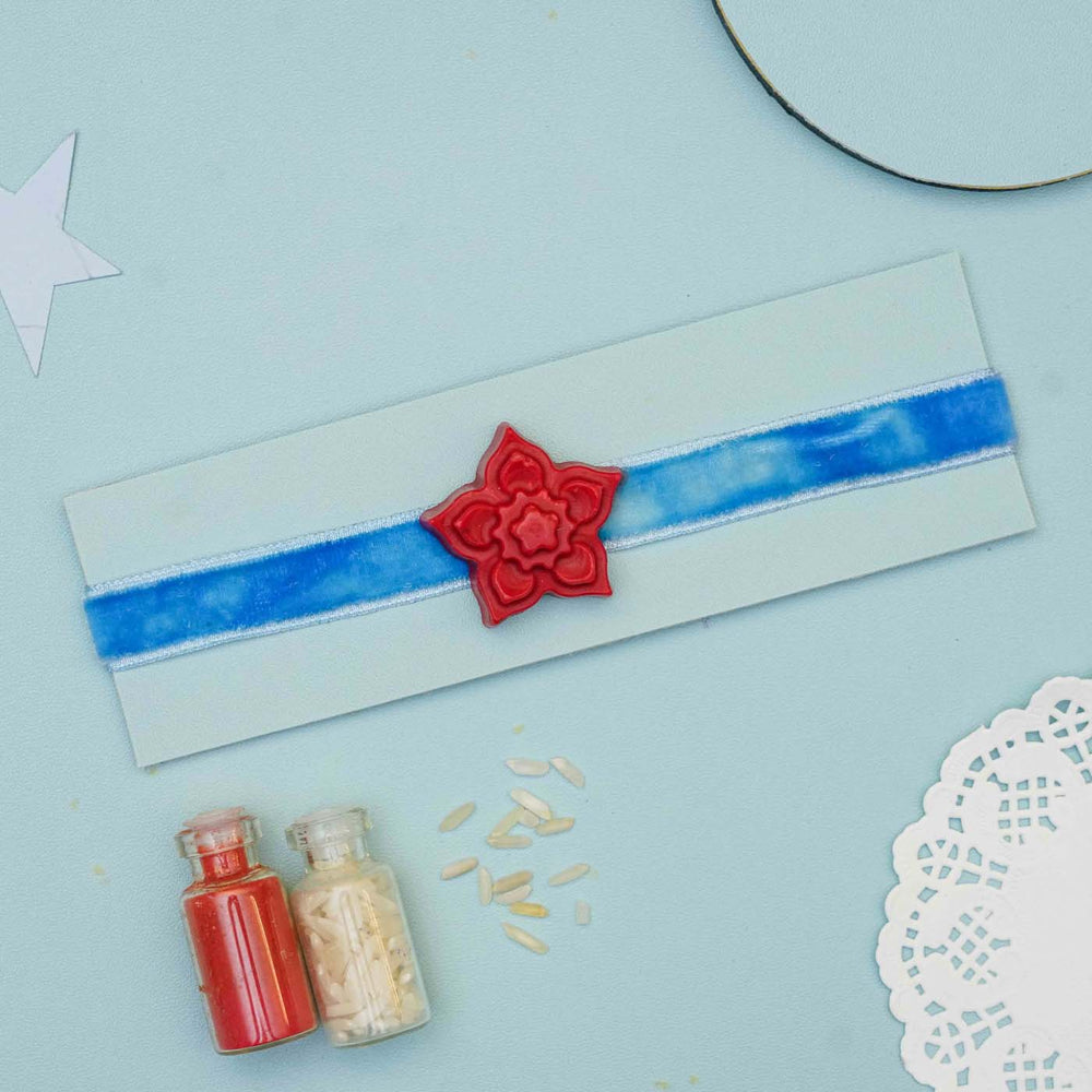 Handmade Flower Crayon Kids Rakhi With Roli Chawal - Full view on blue band with accessories