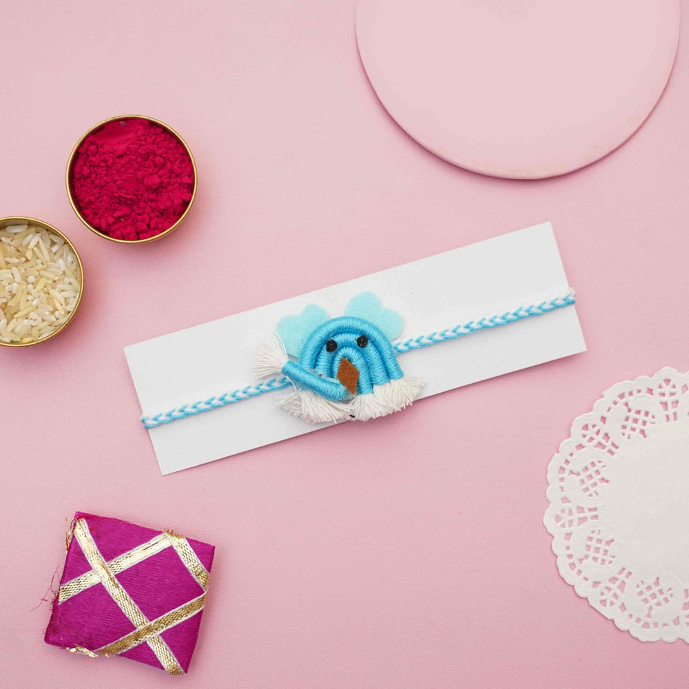 Handmade Macrame Blue Ellie Design Cotton Kids Rakhi With Chocolates And Roli Chawal - Flat Lay with Rakhi on Card