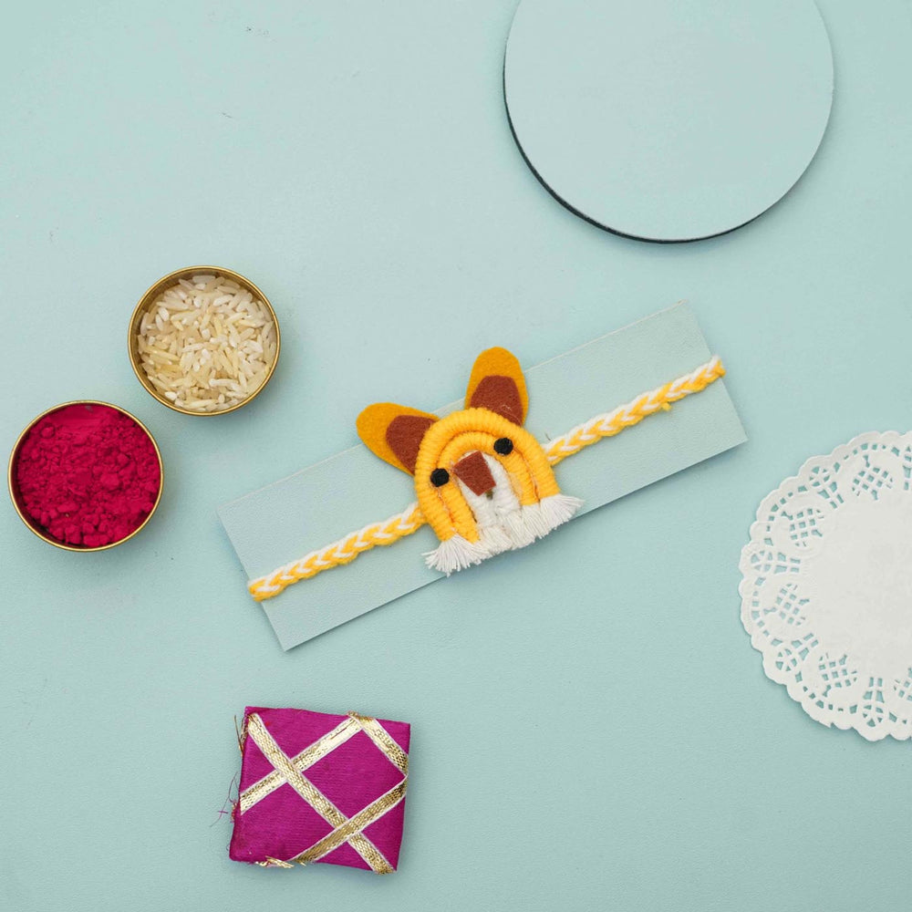 Handmade Macrame Yellow Mouse Design Cotton Kids Rakhi With Chocolates And Roli Chawal - Styled with envelope and items