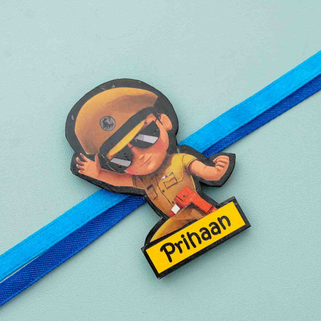 Personalized Reusable X Large Little Singam Mdf Wood Rakhi With Chocolates And Roli Chawal - Close-up of Character Badge