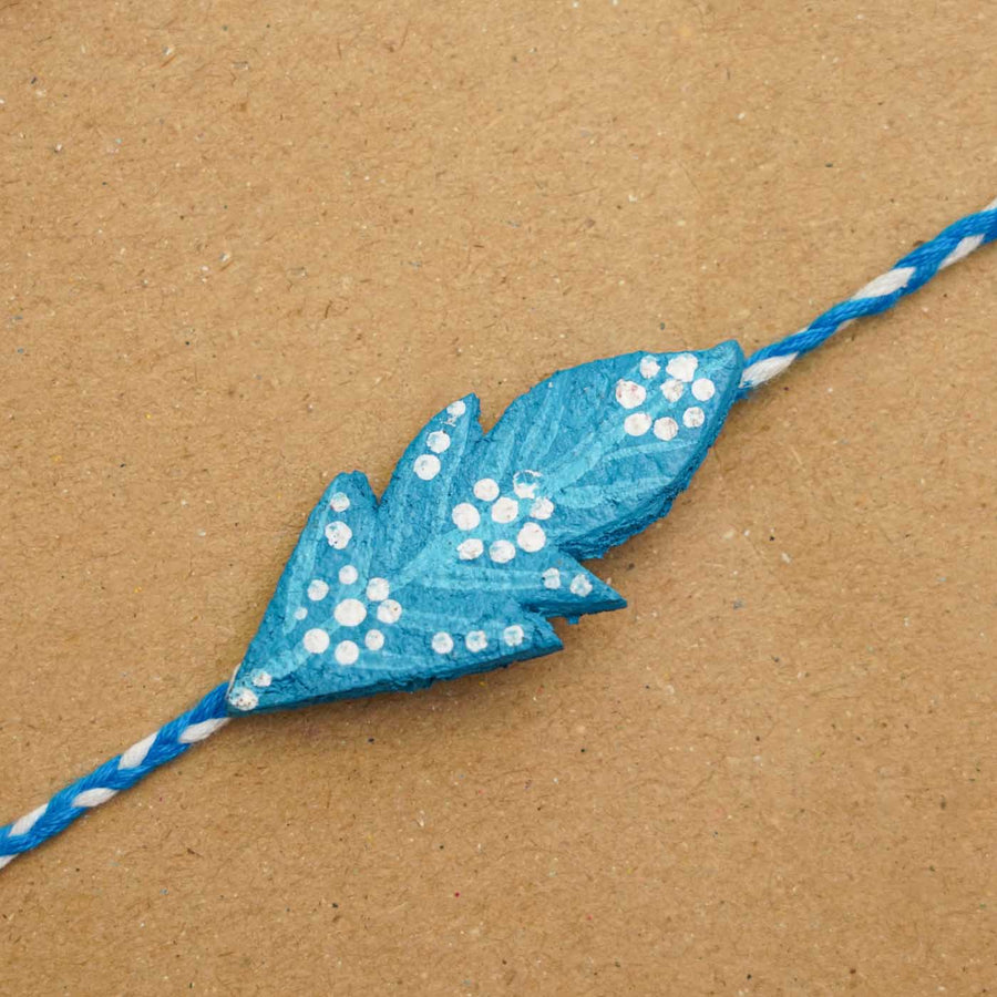 Handmade Ecofriendly Blue Feather Recycled Paper Rakhi With Roli Chawal - Close-up of leaf design