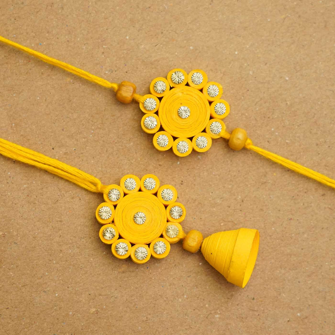 Handmade Ecofriendly Yellow Quilled Recycled Paper Bhaiya Bhabhi Rakhi With Roli Chawal - Flat lay close-up view