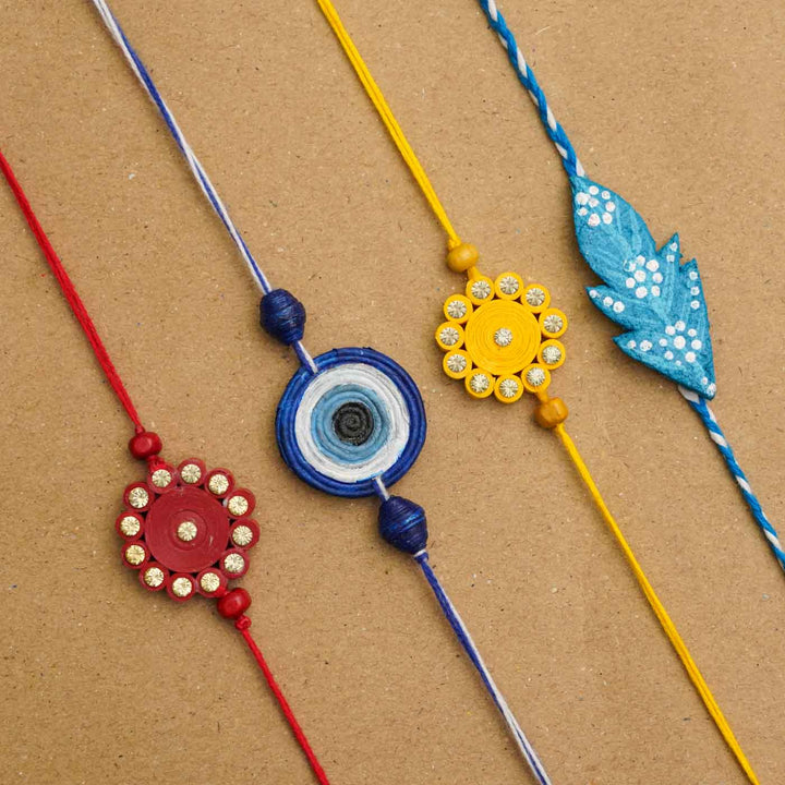 Handmade Ecofriendly Red Quilled Recycled Paper Bhaiya Bhabhi Rakhi With Roli Chawal - Four colorful Rakhis laid flat