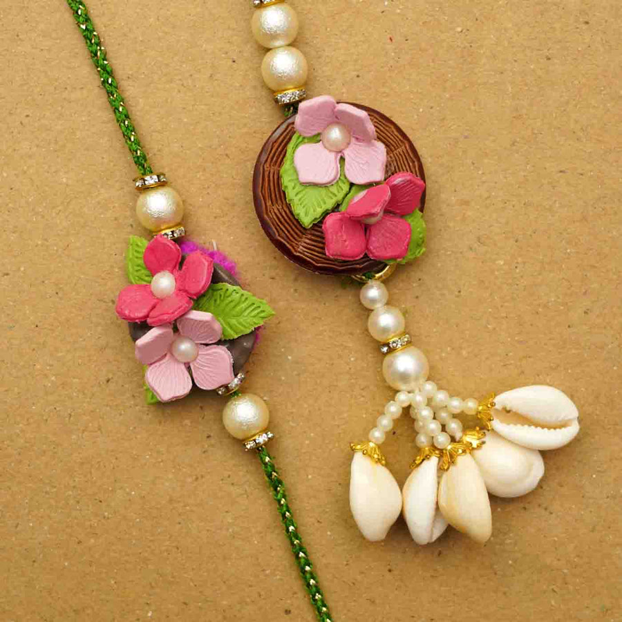 Handmade Pink Floral Clay Bhaiya Bhabhi Rakhi With Chocolates And Roli Chawal Set Of 2 - Close-up of two rakhis