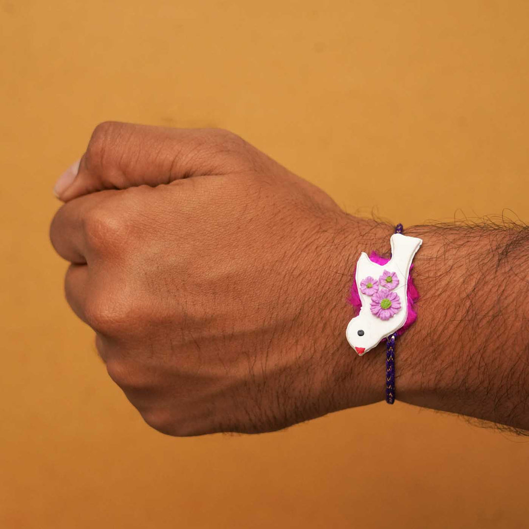 Handmade Bird Clay Rakhi With Chocolates Roli Chawal - Worn on wrist front view