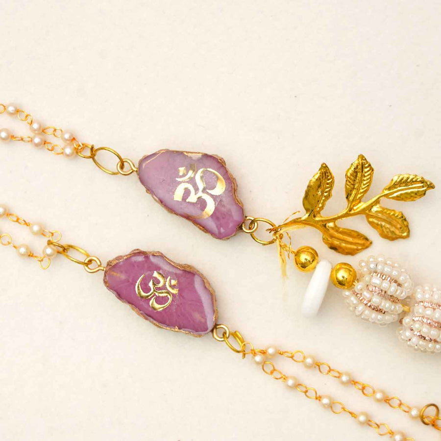 Handmade Om Purple Agate Resin Bhaiya Bhabhi Rakhi With Chocolates And Roli Chawal Set Of 2 - Close-up of necklace pendant details
