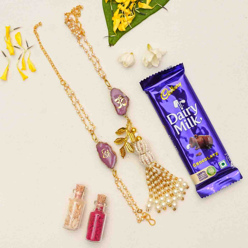 Handmade Om Purple Agate Resin Bhaiya Bhabhi Rakhi With Chocolates And Roli Chawal Set Of 2 - Necklace next to chocolate and decor