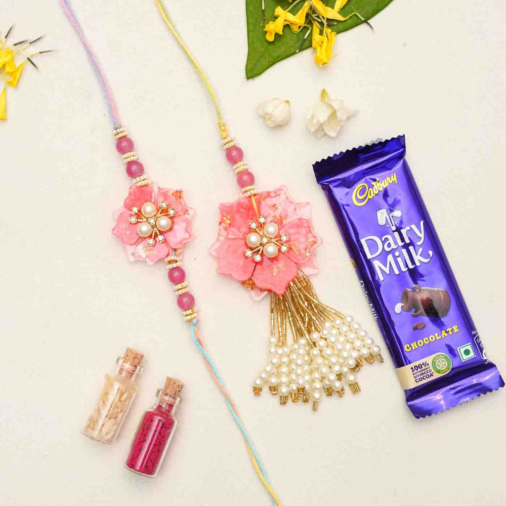 Handmade Resin Pink Flower With Pearls Bhaiya Bhabhi Rakhi With Chocolates And Roli Chawal Set Of 2 - Rakhis with chocolate and decorative items