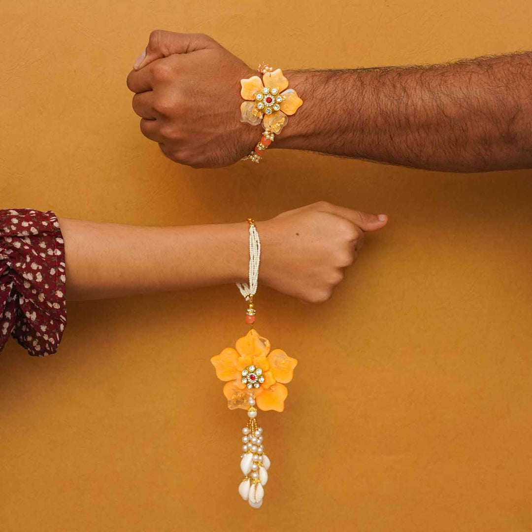 Handmade Yellow Flower Theme Resin Bhaiya Bhabhi Rakhi With Chocolates And Roli Chawal For Bhaiya And Bhabhi Set Of 2 - Rakhi Set on Model Wrists