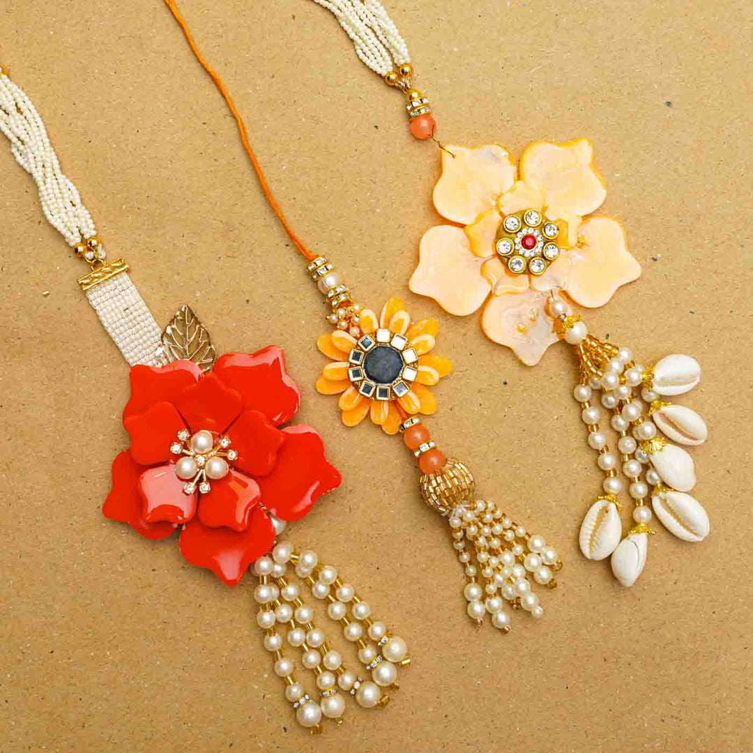 Handmade Yellow Flower Theme Resin Bhaiya Bhabhi Rakhi With Chocolates And Roli Chawal For Bhaiya And Bhabhi Set Of 2 - Assorted Rakhis Displayed Together