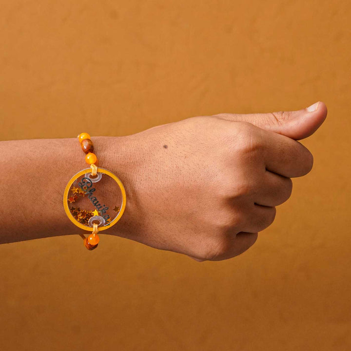 Personalized Handmade Round Glitter Acrylic Rakhi With Roli Chawal - Model wrist wearing bracelet