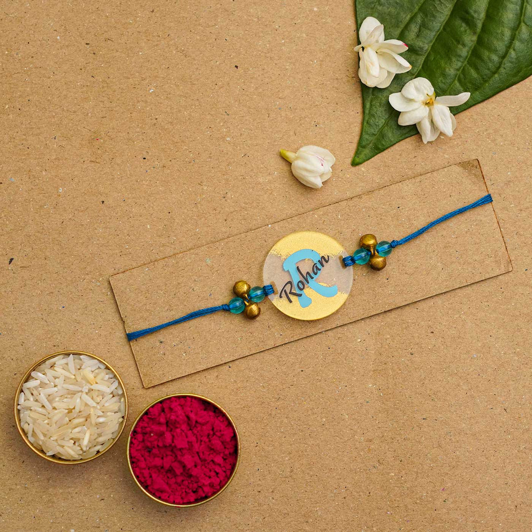 Personalized Handmade Alphabet Golden Acrylic Rakhi With Roli Chawal - Rakhi on Card with Rice and Color (5)