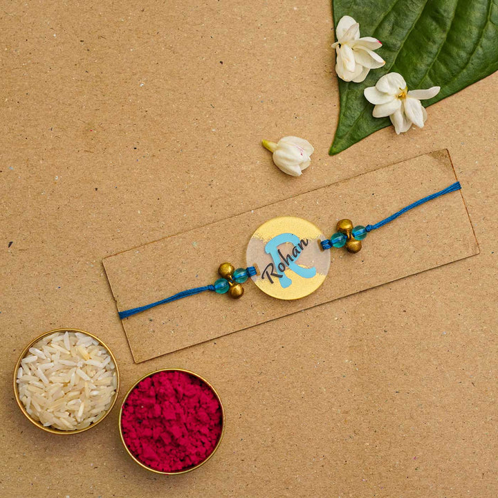 Personalized Handmade Alphabet Golden Acrylic Rakhi With Roli Chawal - Rakhi on Card with Rice and Color (5)