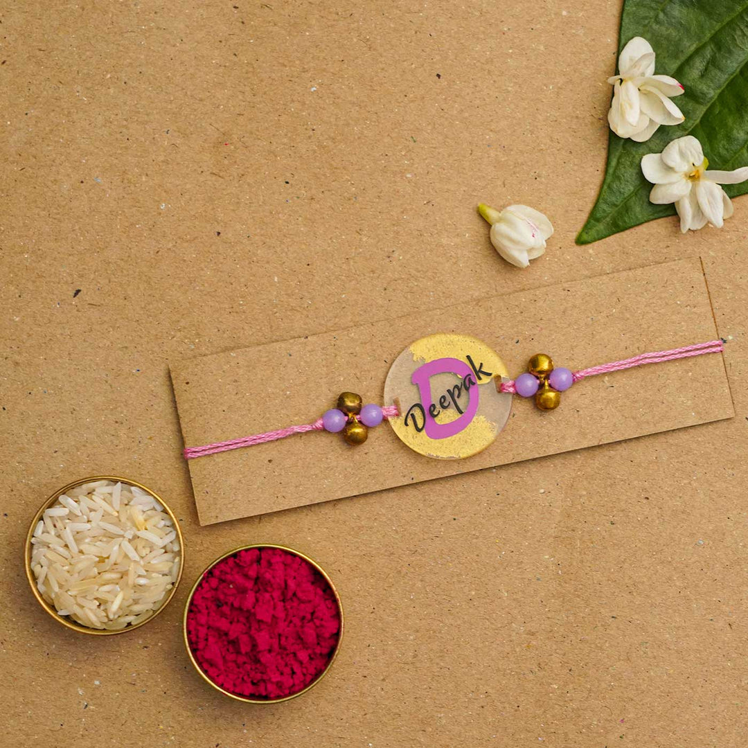 Personalized Handmade Alphabet Golden Acrylic Rakhi With Roli Chawal - Rakhi on Card with Rice and Color