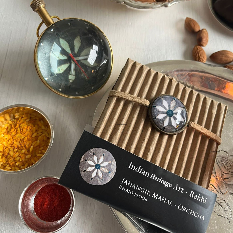 Handcrafted Folk Art Rakhi Hamper For Young Adults With Rice Roli Haldi 1 - Close-up of paper weight clock and rakhi