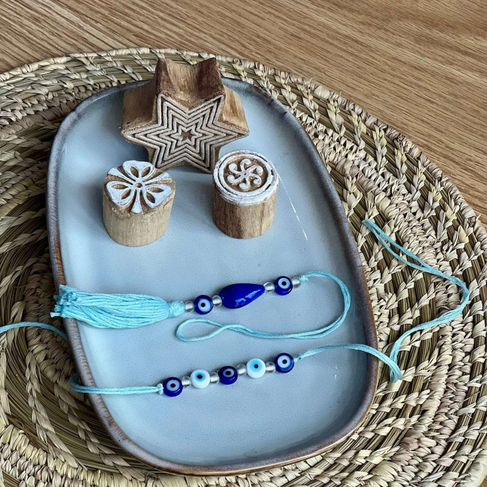 Handmade Beaded Evil Eye Jute Bhaiya Bhabhi Rakhi With Roli Chawal Set Of 2 - Top View with Wooden Stamps