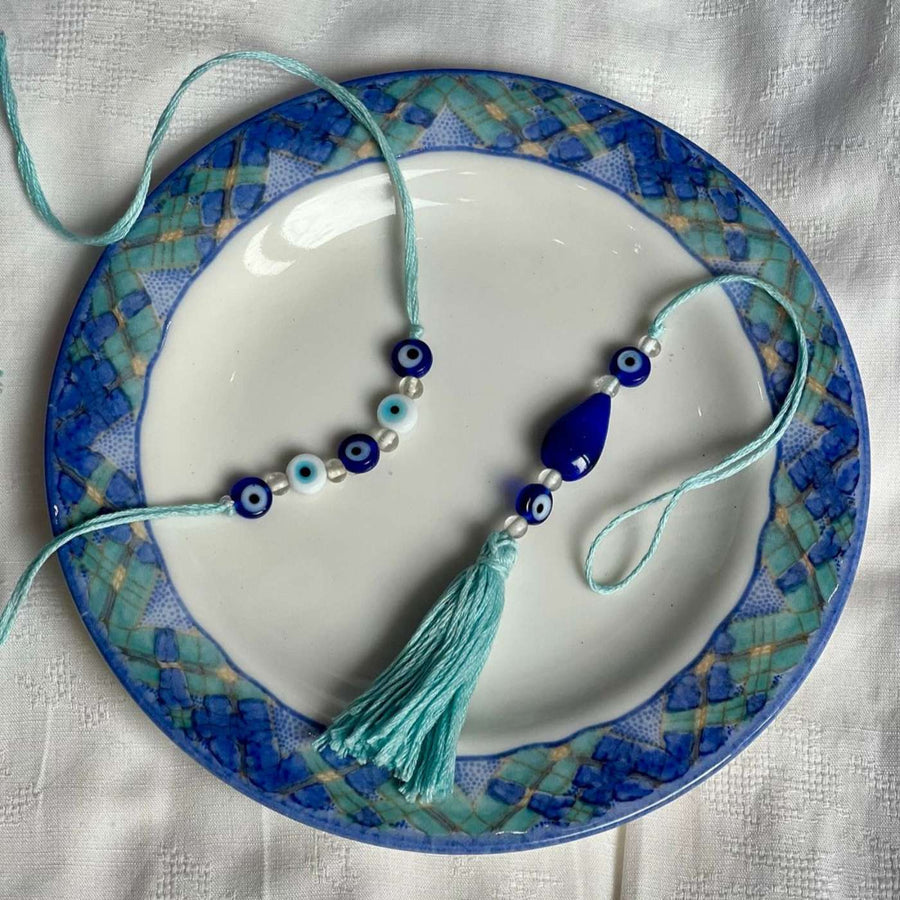 Handmade Beaded Evil Eye Jute Bhaiya Bhabhi Rakhi With Roli Chawal Set Of 2 - Top View on Decorative Plate