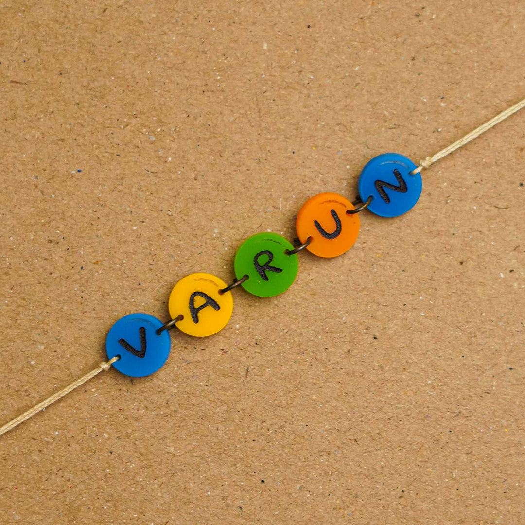 Personalized Handmade Gems Acrylic Rakhi With Roli Chawal - Close-up of name beads on string (5)
