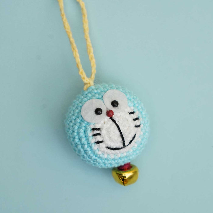 Handmade Crochet Doraemon Kids Rakhi With Roli Chawal - Close-up of Charm with Bell