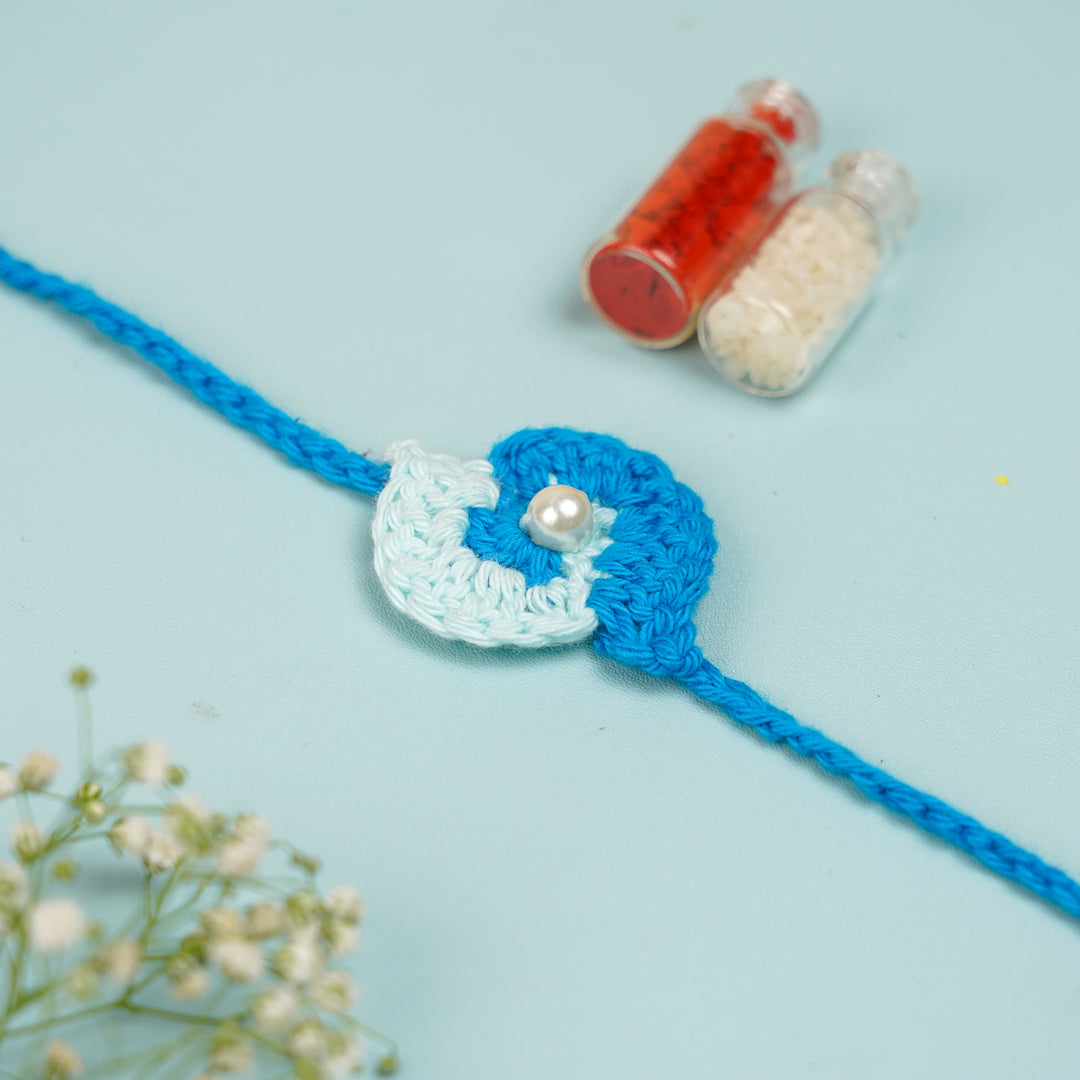 Customized Handmade Crochet Spiral Rakhi With Roli Chawal For Brother - Flat Lay Front View with Roli Chawal