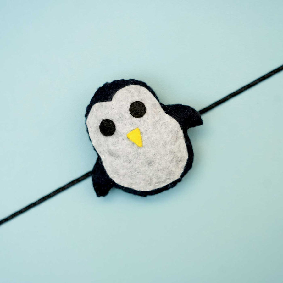 Handmade Penguin Felt Rakhi With Roli Chawal - Close-up of single penguin charm
