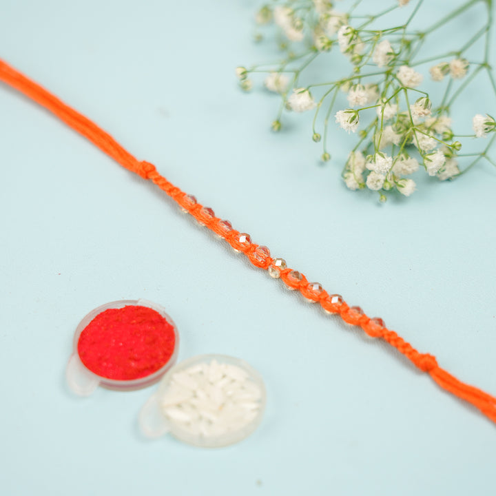 Handmade Jadtar Crystal Bhaiya Bhabhi Rakhi With Roli Chawal Set Of 2 - Flat lay of beaded string section