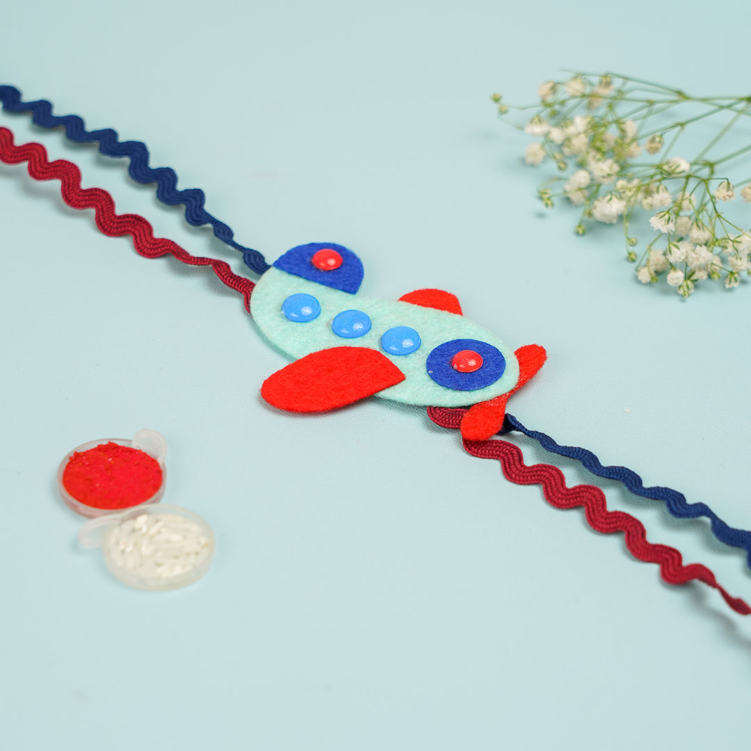 Handmade Aeroplane Theme Felt Kids Rakhi With Roli Chawal - Decorative View with Sewing Accessories