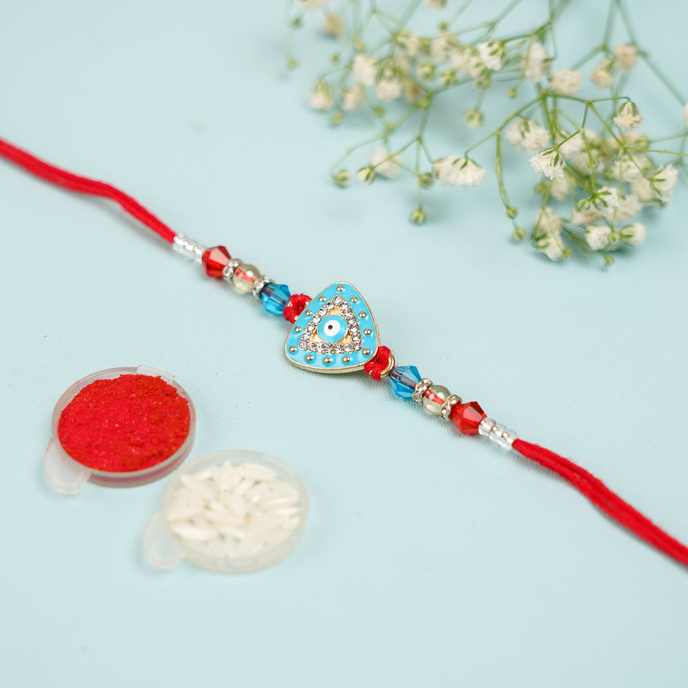 Handmade Triangle Evil Eye Rakhi With Roli Chawal - Flat Lay with Decorative Accessories