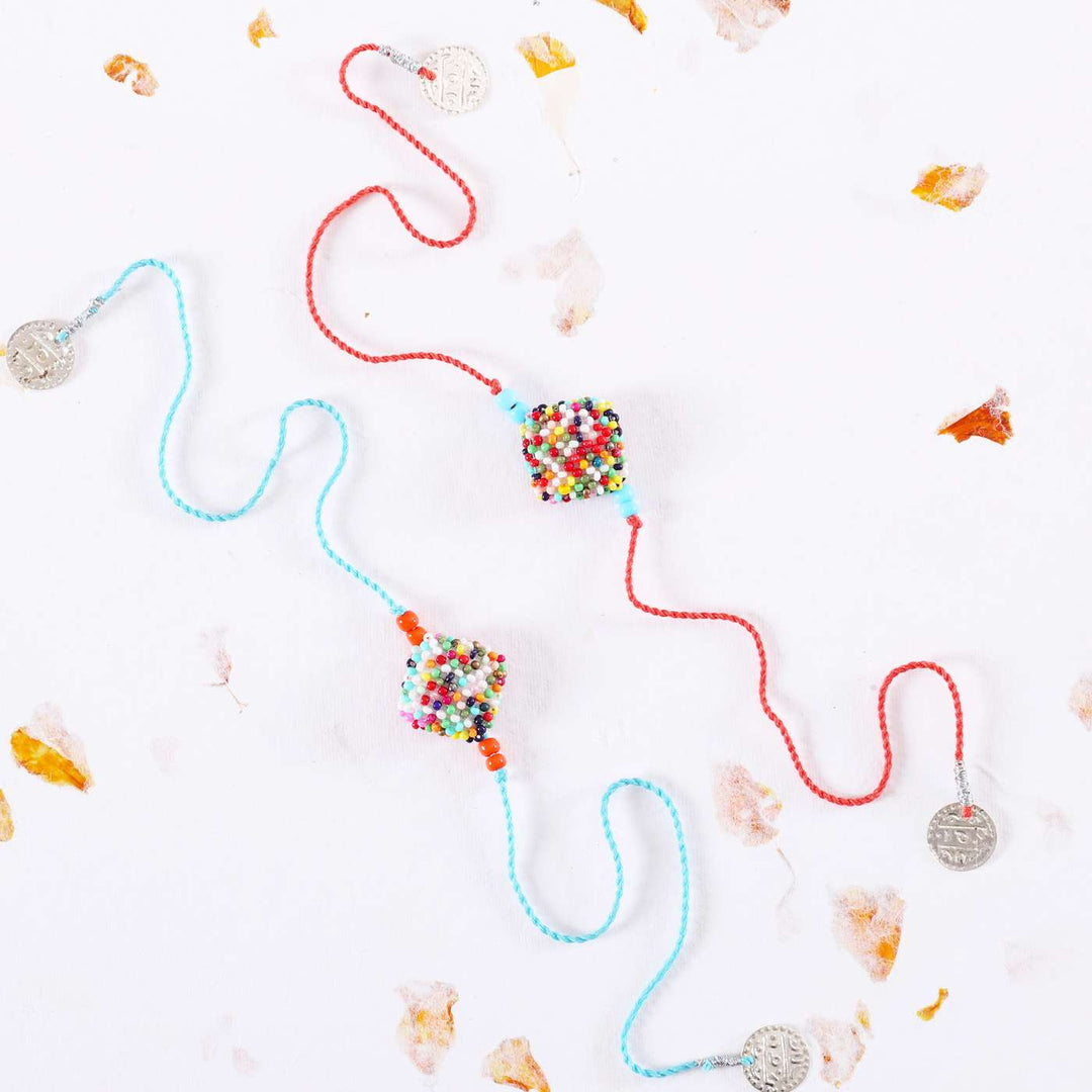 Handmade Beaded Square Rakhi With Roli Chawal Set Of 2 - Flat Lay on White Background
