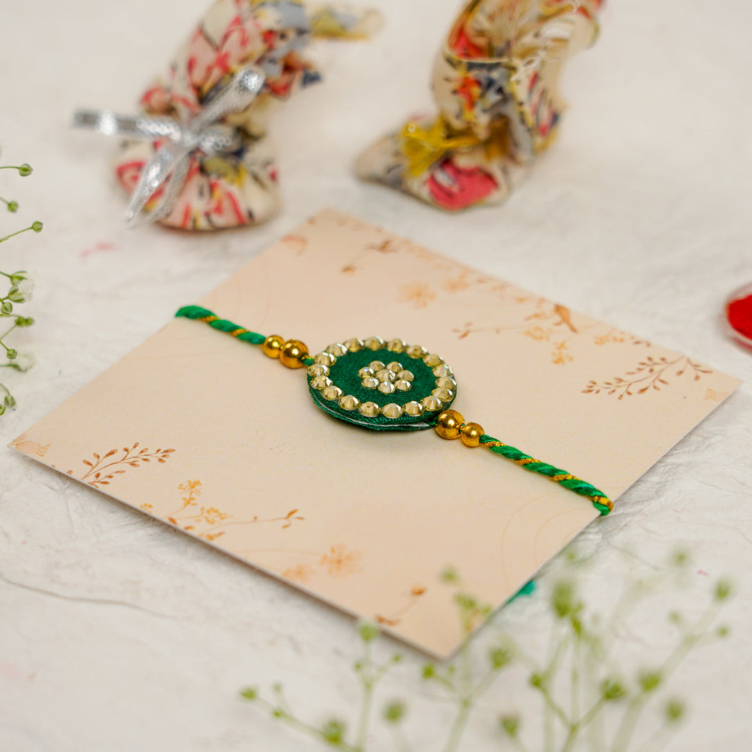 Handmade Silk Crystal Rakhi With Roli Chawal - Angled View Green Rakhi on Card