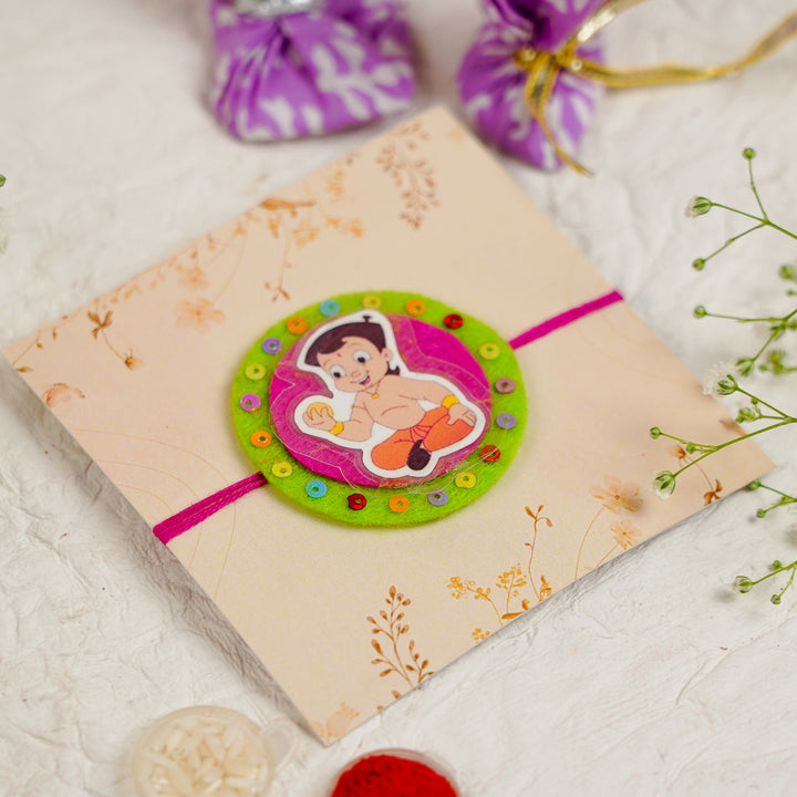 Handmade Chota Bheem With Ladoo Rakhi With Roli Chawal - Flat Lay with Packaging and Items (6)