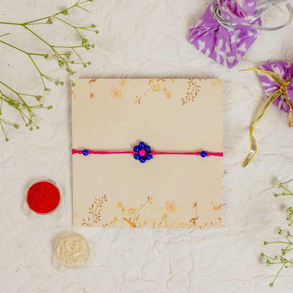 Handmade Beaded Flower Rakhi With Roli Chawal - Flat lay with box and accessories