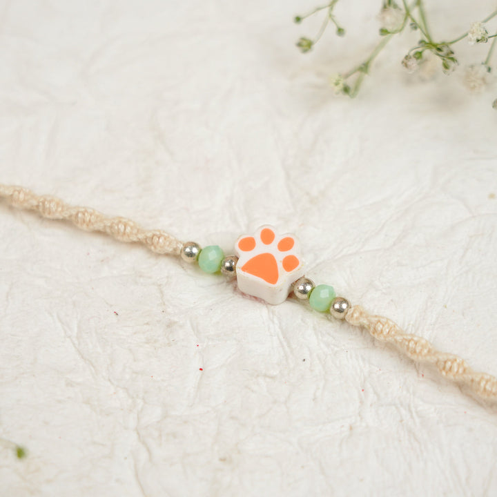 Handmade Paw Kids Rakhi With Roli Chawal - Close-up Orange Paw Charm