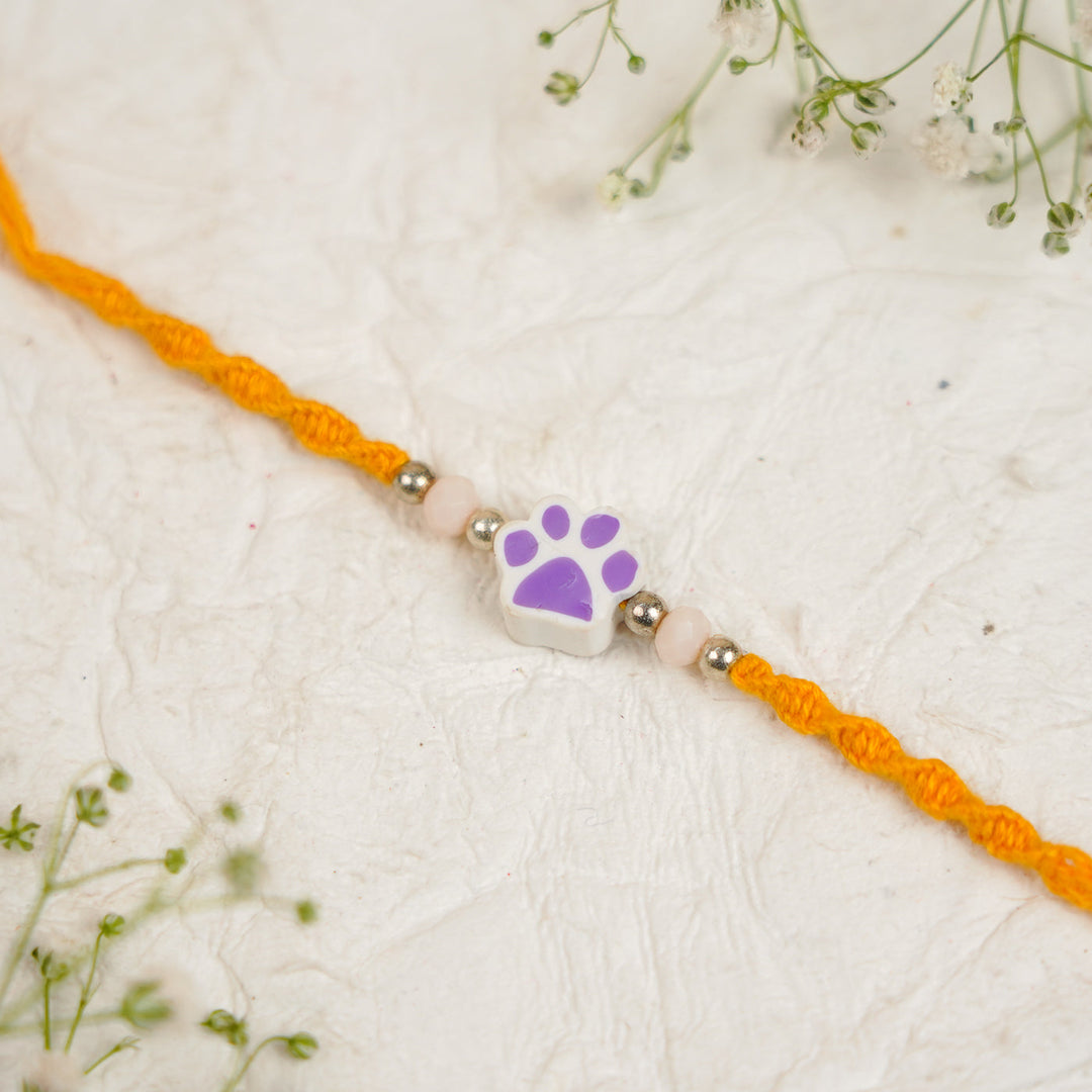 Handmade Paw Kids Rakhi With Roli Chawal - Close-up Purple Paw Charm
