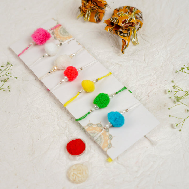 Handmade Pompom Rakhi With Roli Chawal Set Of 12 - Angled Close-up of Rakhi Set