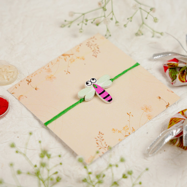 Handmade Dragon Fly Kids Rakhi With Roli Chawal - Angled Close-up View