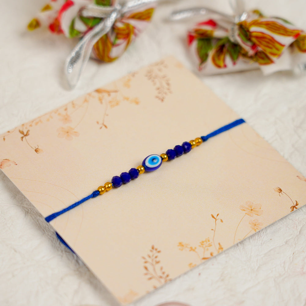Handmade Blue Evil Eye Rakhi With Roli Chawal - Angled Close-up View