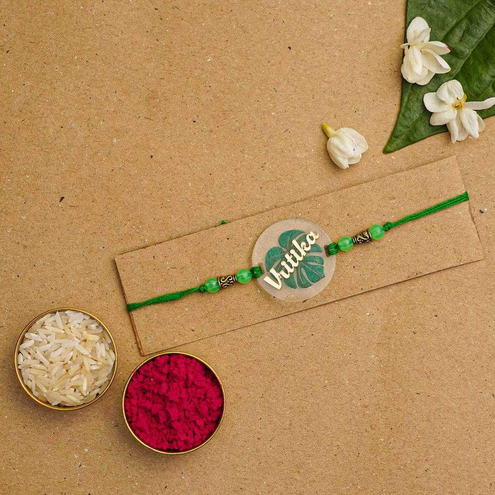 Personalized Handmade Leaf Acrylic Rakhi With Roli Chawal - Flat Lay with Traditional Elements